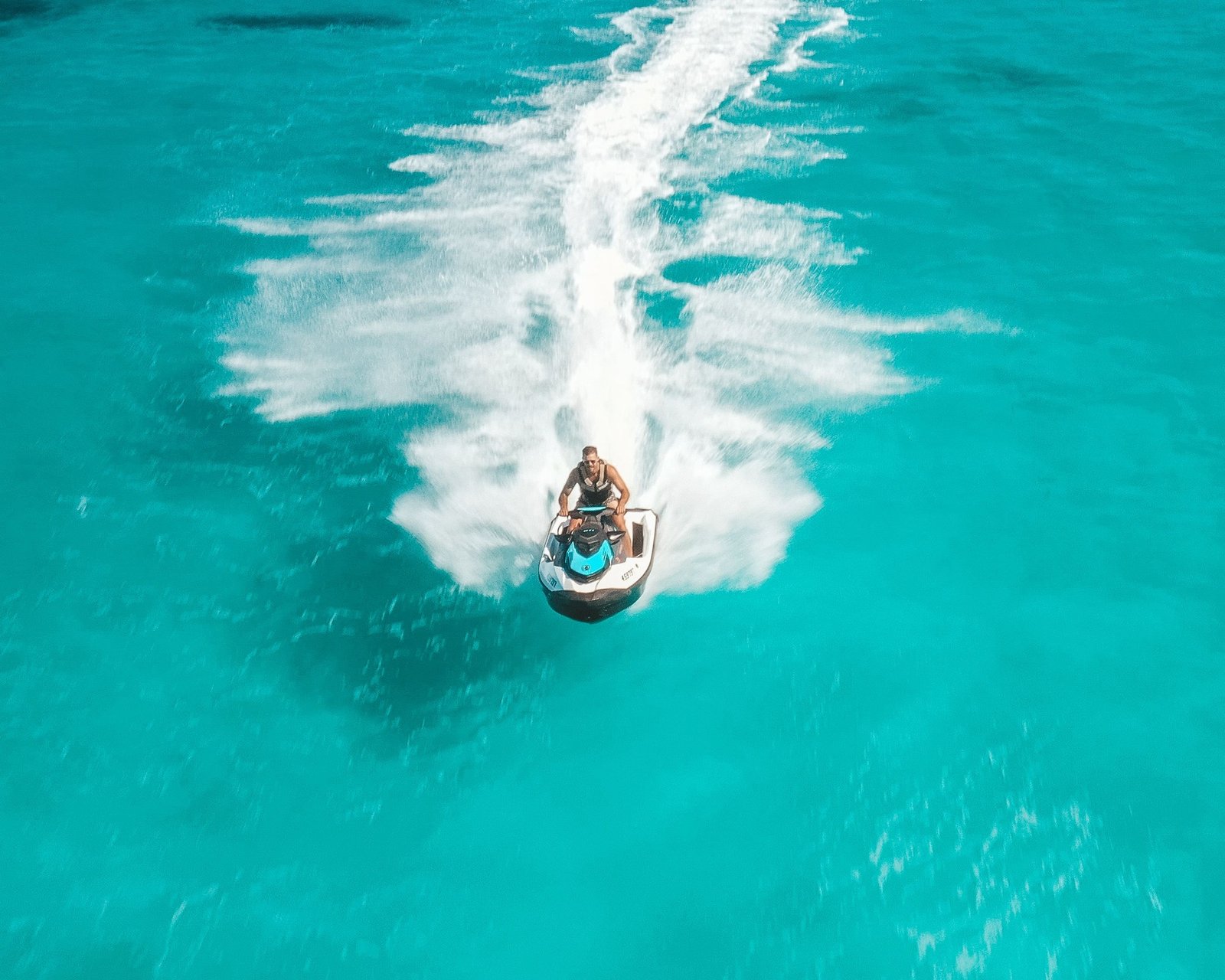 View of a person riding a jet ski on clear turquoise water
